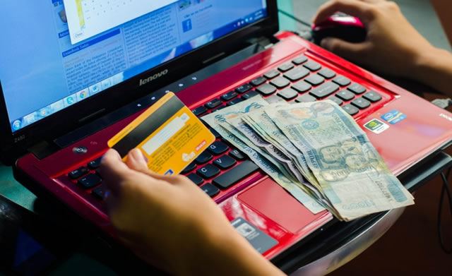 Девушка выполняет онлайн платеж с банковской карты