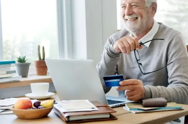 Пожилой мужчина радуется возможности управлять счетами через онлайн-банк