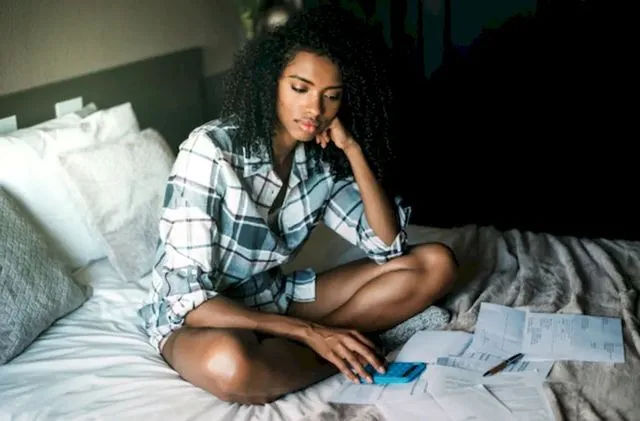 Взволнованная темнокожая женщина изучает свои долговые обязательства