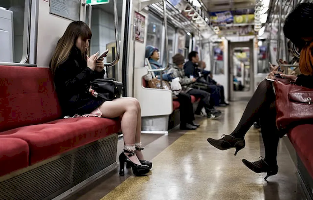 Девушки в метро со смартфонами в руках